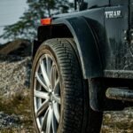 Detailed view of an off-road vehicle's wheel on a dirt path in Punjab, India.